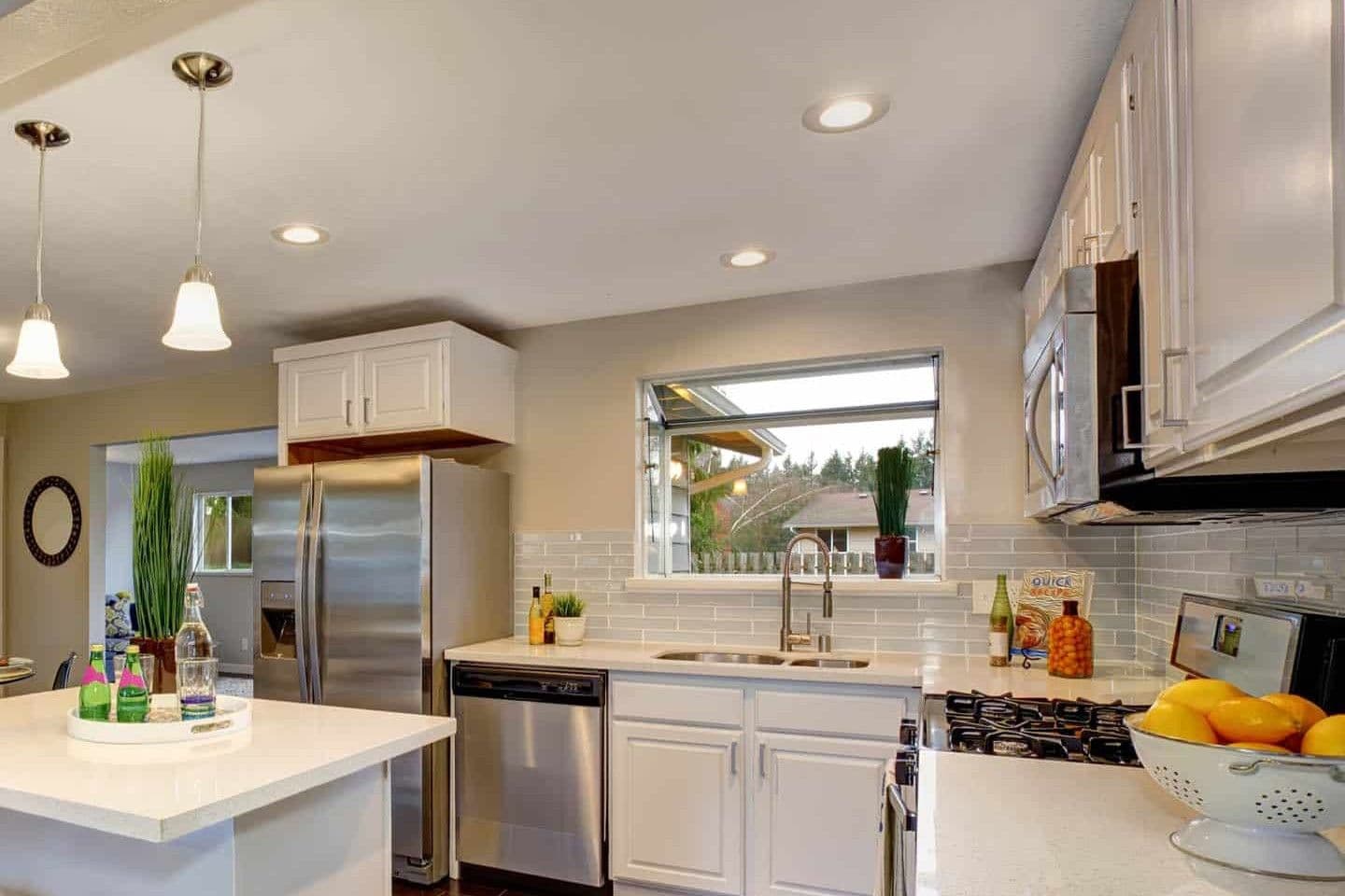 A beige kitchen with a garden window above the sink.