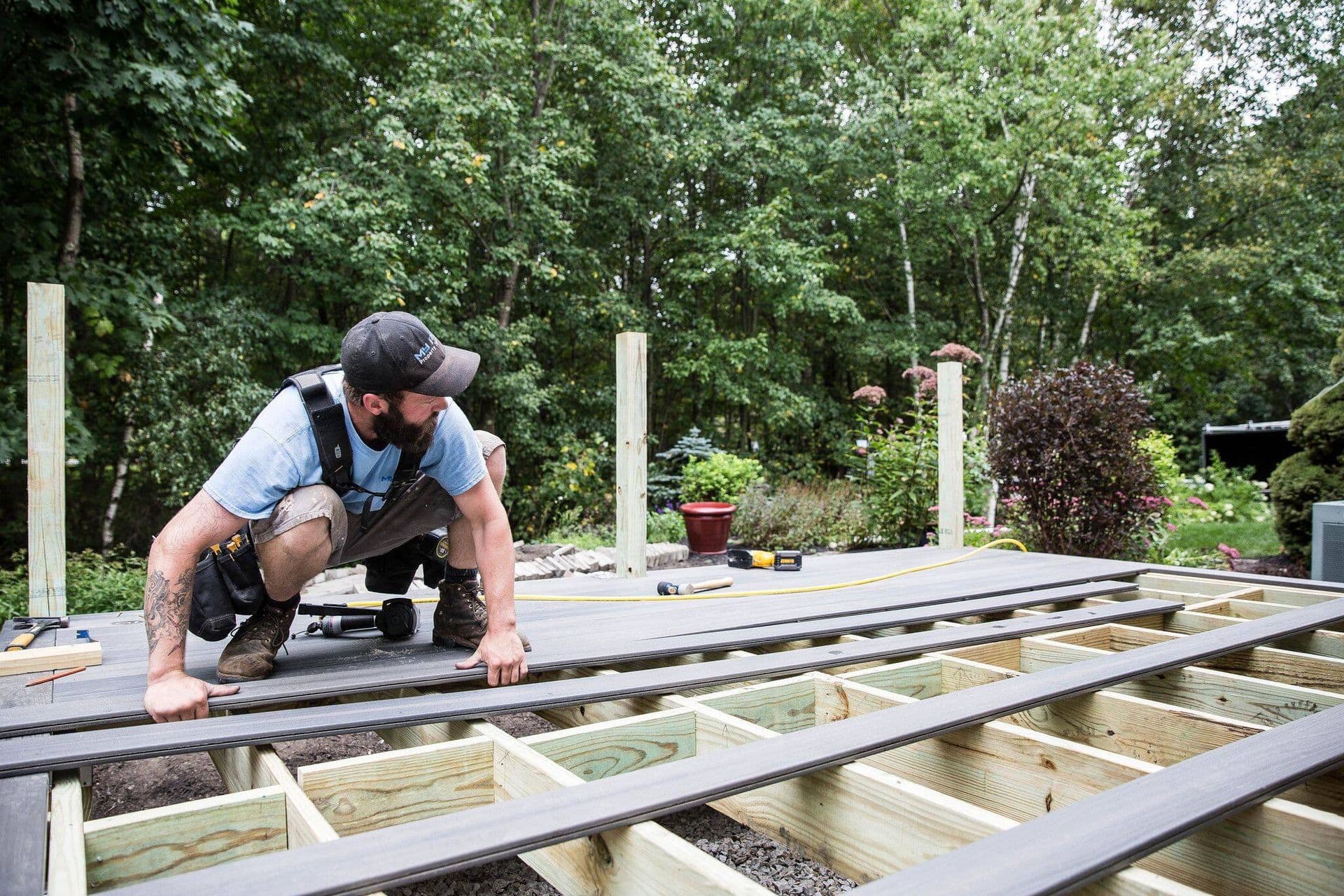 A worker installs new gray decking.