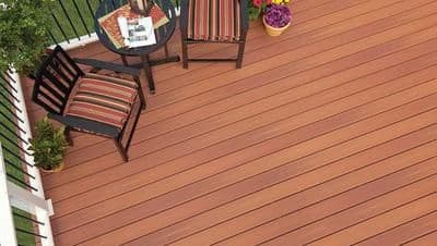 An overhead view of a medium brown deck with black patio furniture.