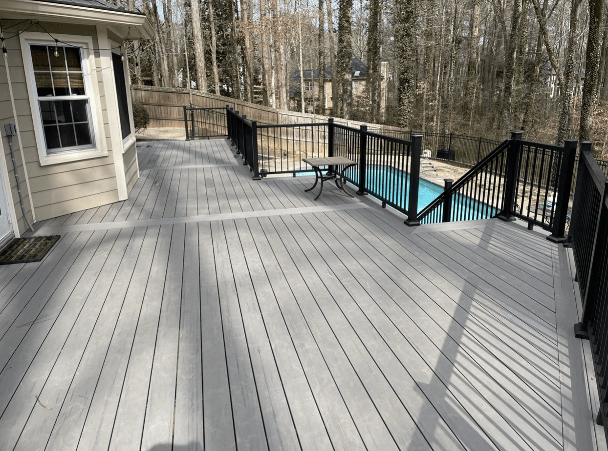 A light gray deck with black railings.