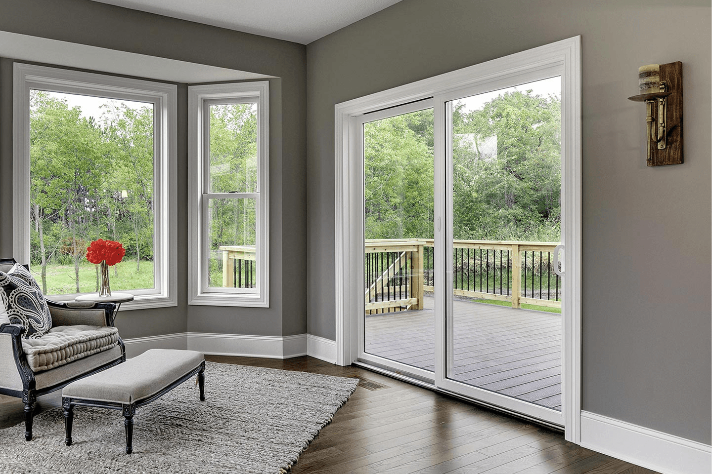 A gray living room with sliding patio doors and a bay window.