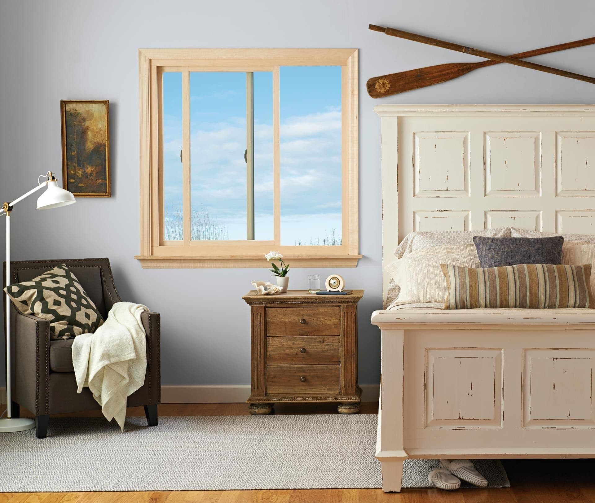 Sliding windows in natural-colored frames in a gray bedroom.