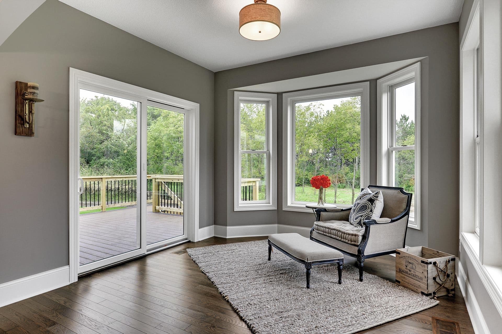A gray living room with sliding patio doors and a bay window.