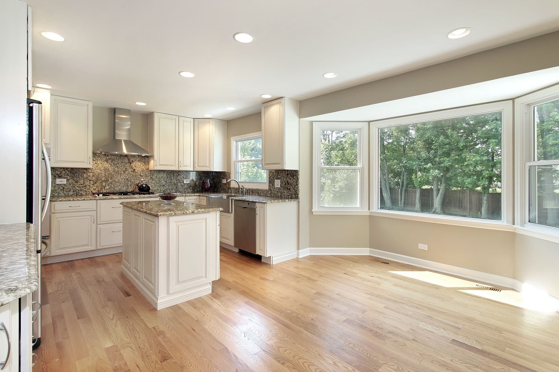 A gray kitchen with a large bay picture window.