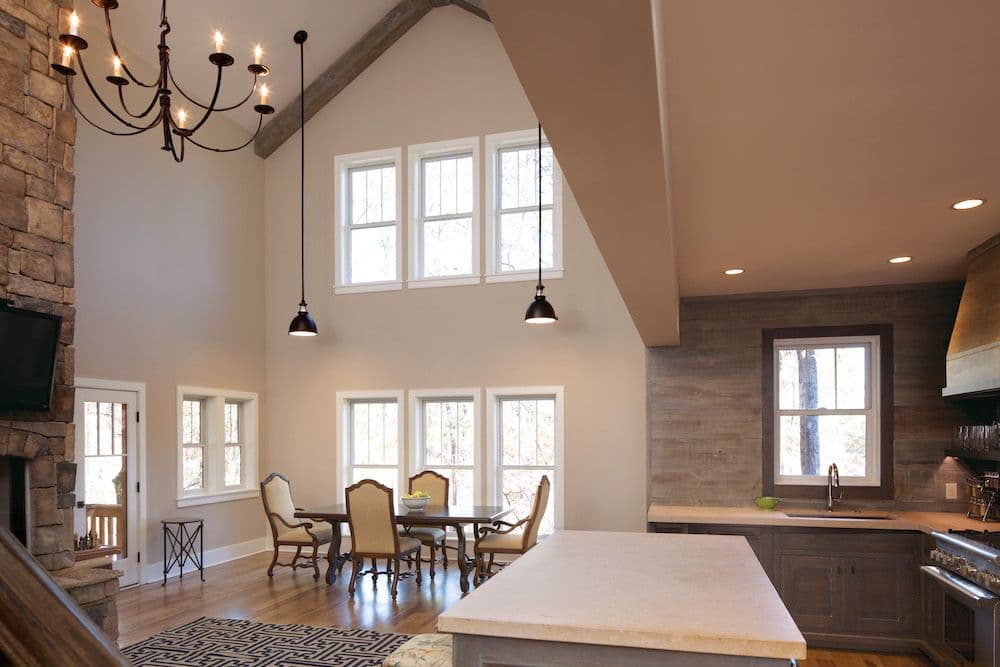 A living and dining room area with tall ceilings and two stories of single-hung windows.