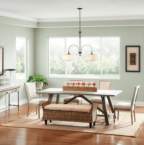A light gray-green dining room with sliding windows overlooking a yard.