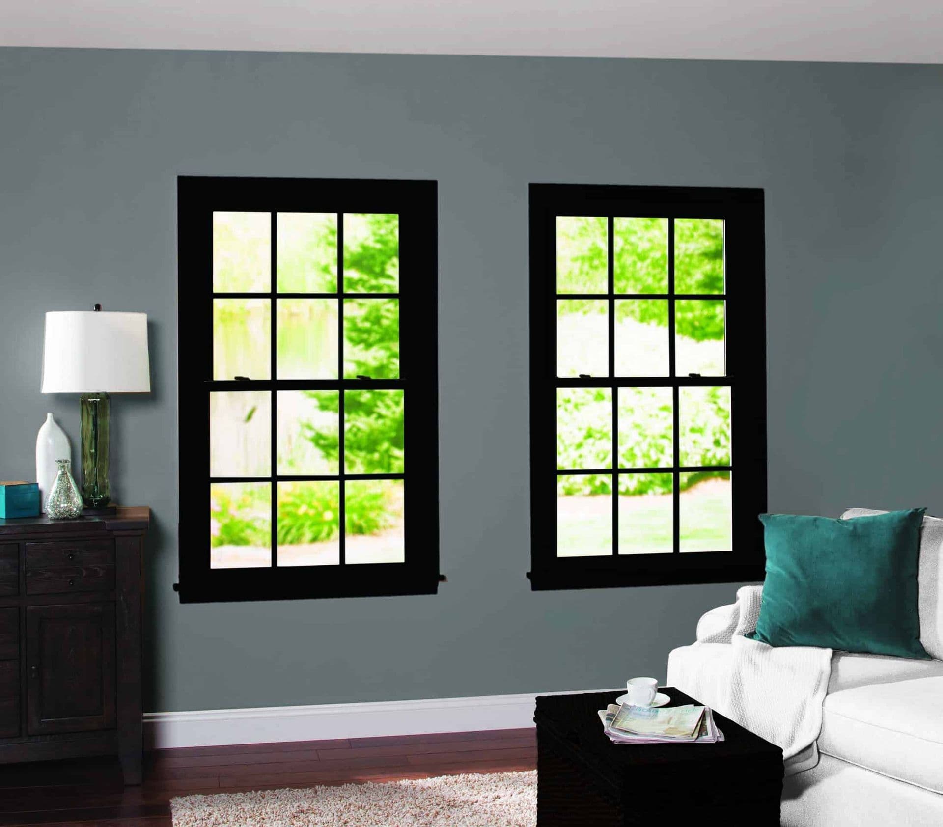 A gray living room with two black double-hung windows.
