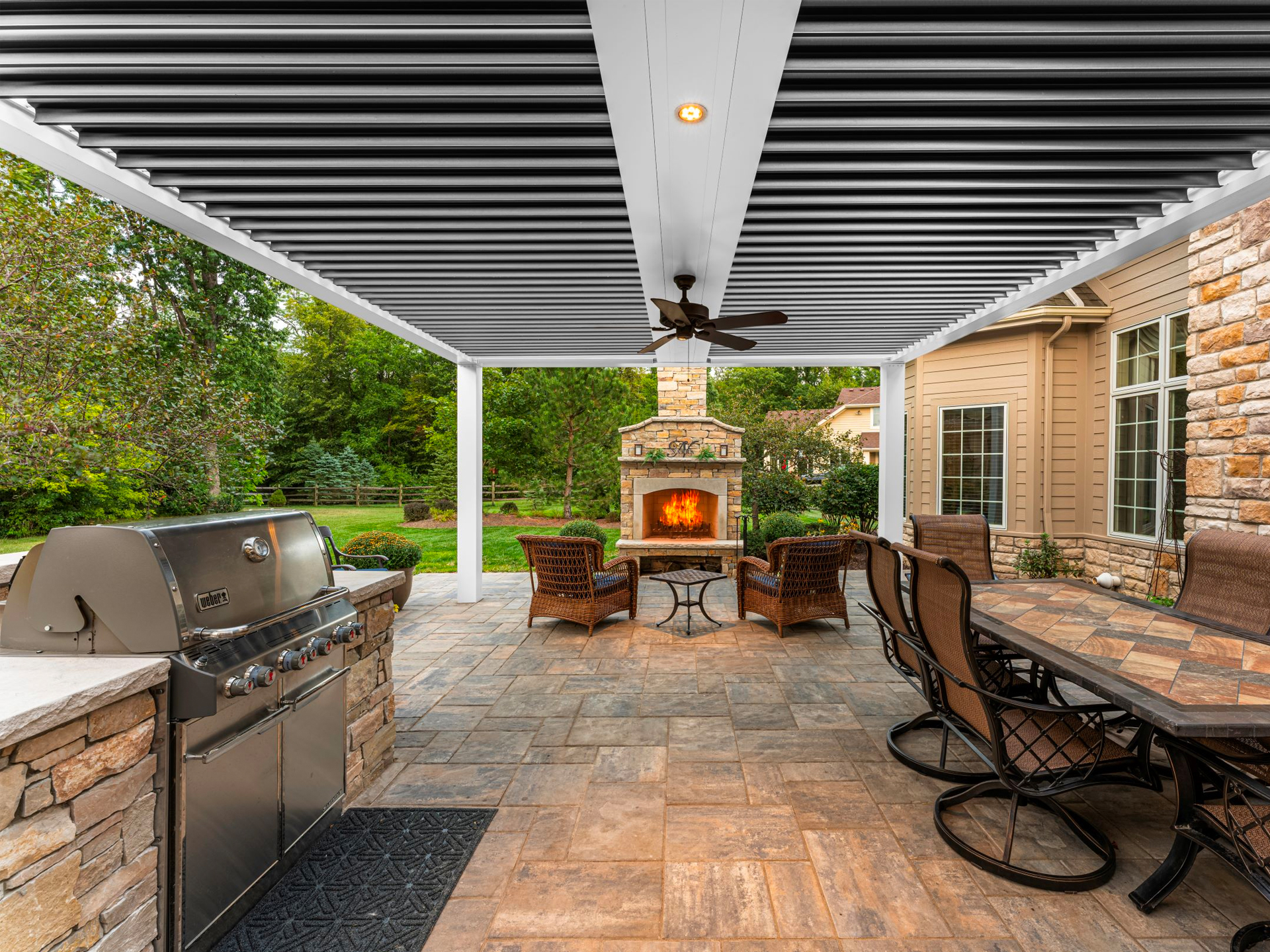 A stone patio covered by a motorized pergola.