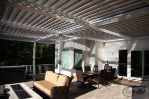 A large louvered pergola over a deck