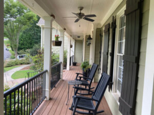 a composite deck on front of home with rocking chairs