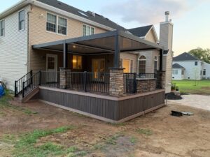 louvered pergola installed over back deck of home